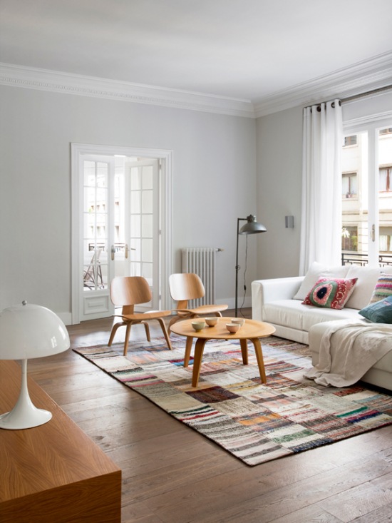 Biały salon z dywanem patchwork i drewnianym stolikiem w stylu skandynawskim