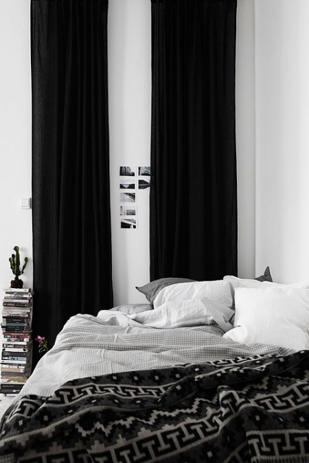 Czarne zasłony w białej sypialni,szara pościel,czarno-biała narzuta i pledy