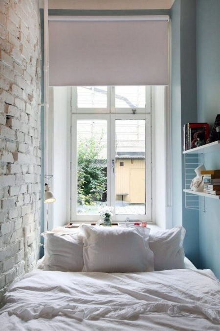 Mała sypialnia z białą cegłą na ścianie