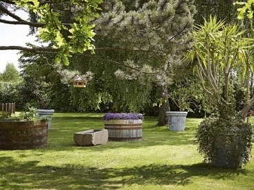 Pomysł na ogród z kompozycją dużych donic kamiennych i drewnianych z roślinnymi kompozycjami (25041)