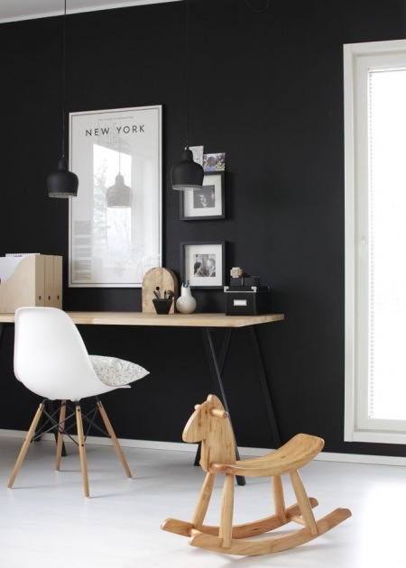 Czarna ściana, biała podloga,skandynawskie biurko na czanych metalowych nogach z drewnianym blatem ,białe krzesło na drewnianych nóżkach i drewniane detale w domowym biurze