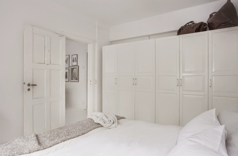 Białe szafy w aranżacji skandynawskiej sypialni