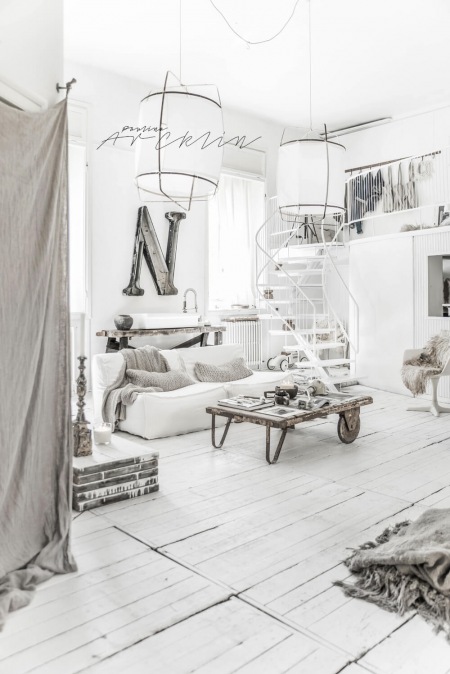 Biały przestronny salon z antresolą w skandynawskim stylu
