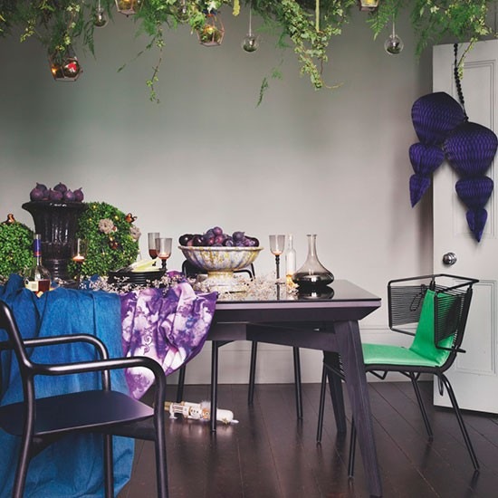 Fiolety i zielenie w aranzacji światecznej jadalni w zmiksowanej stylowo jadalni z czarnym stołem