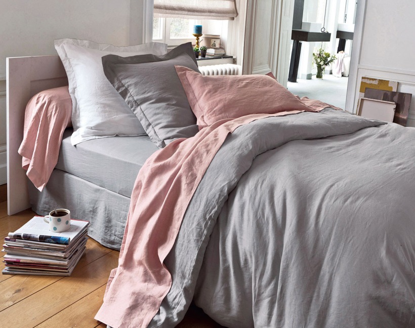 Szaro-różowa pościel na łóżku w sypialni