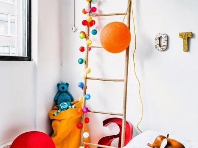 Kolorowe pomponiki i kule na drewnianej drabinie dekoracyjnej w pokoju dziecięcym (26919)