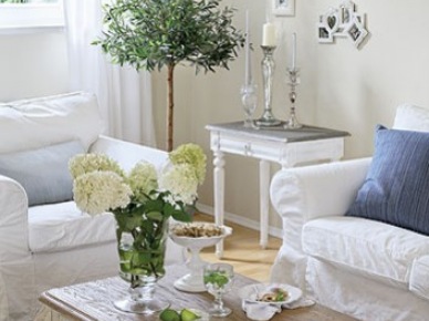 Prowansalski stolik kawowy,biały stolik pomocniczy,biała sofa i stylowe świeczniki w salonie (21273)