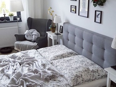 Aranżacja sypialni jest elegancka, ale także znajdują się w niej elementy dodające ciepła. Wezgłowie łóżka obite szarym materiałem wygląda stylowo i potęguje przytulność...
