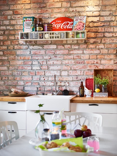 Ściana z czerwonej cegły w małej kuchni w stylu skandynawskim