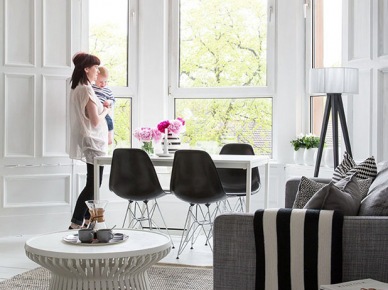 Biały nowoczesny stó z czarnymi krzesłami na metalowych nóżkach urządzony w wykuszu w salonie (21550)
