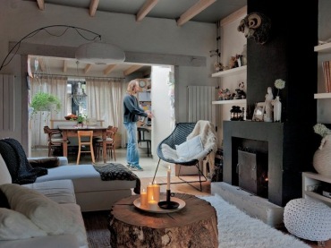 To jest przykład aranżacji salony w bardzo przytulnym klimacie. Puszysty dywan, stolik jakby pieniek z drewna, jasny...