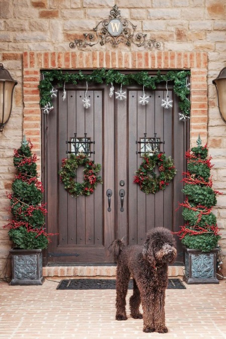Czerwone dekoracje świąteczne w wazonach i na drzwiach