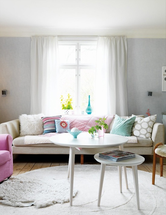 Turkusowe i różowe poduszki na białej sofie