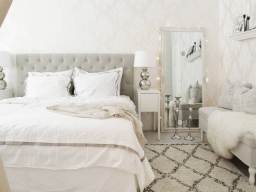 Sypialnię urządzono w eleganckim stylu, bazując na rozbielonej bieli i wielu dodatkach. W centralnym punkcie pokoju...