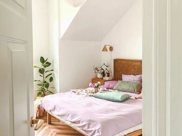 W sypialni dominuje drewno, a szczególnie efektownie wygląda parkiet w jodełkę. Również rama łóżka jest drewniana i ma oryginalne, pikowane wezgłowie w brązowym kolorze. Cała aranżacja wygląda dość spokojnie i...