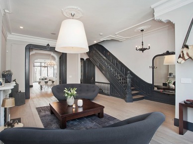 Stylowe szaro-grafitowe schody w salonie z nowoczesną szarą kanapą,kolonialnym stolikiem i nowoczesną biała lampą (24424)