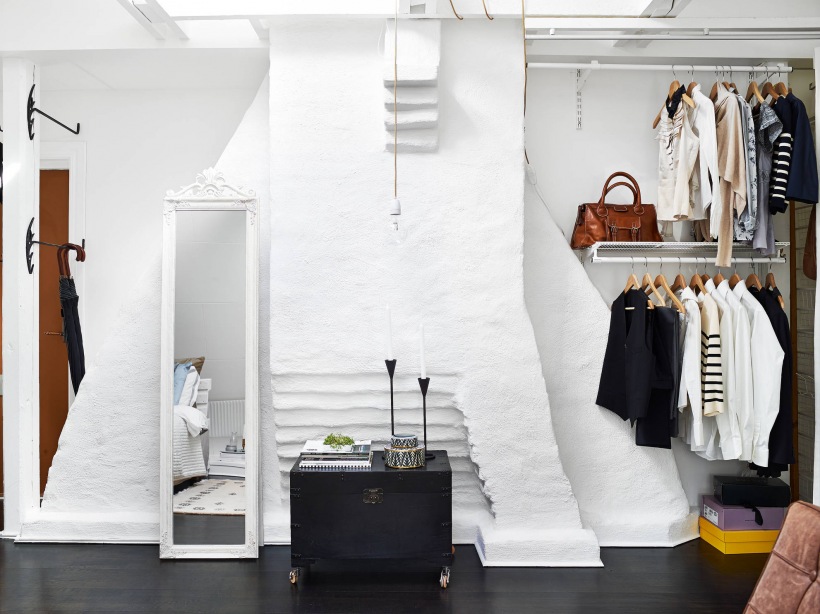 Malowana biała cegła, czarna podłoga i skrzynia w aranżacji przedpokoju-garderoby łącznie