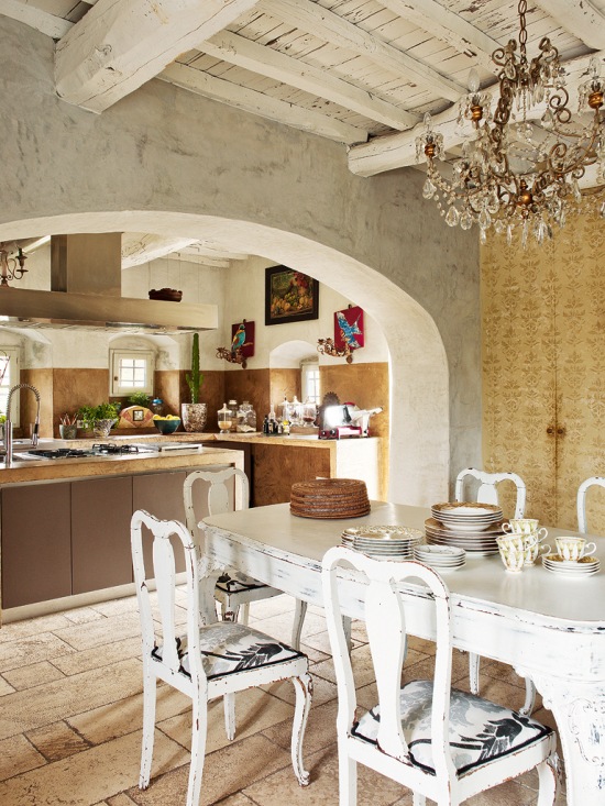 Otwarta kuchnia z jadalnią z kryształowym żyrandolem i francuskimi krzesłami