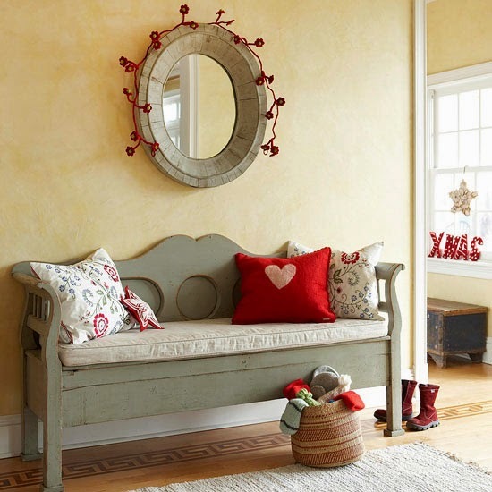 Szara ławka  z drewna i owalne lustro w stylu prowansalskim z czerwonymi świątecznymi dekoracjami
