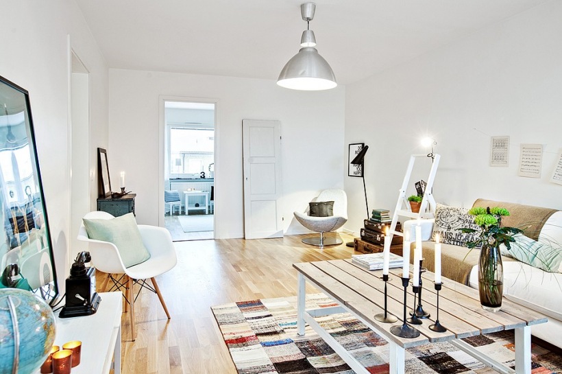 Skandynawski salon z dywanem patchwork,drewnianą ławą,białą sofą i metalową lampą