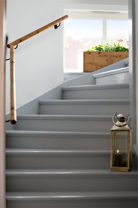 Szare malowane schody z toczoną w drewnie balustradą