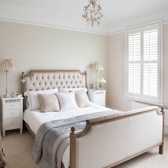 Klasyczna sypialnia z drewnianym łóżkiem z tapicerowanymi bokami w tkaninie