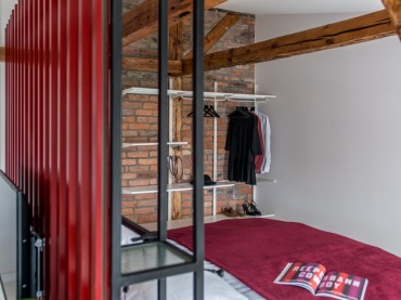 W sypialni jeden fragment ściany został wyłożony czerwonymi cegłami. Razem z drewnianymi belkami tworzą one oryginalny i naturalny efekt....