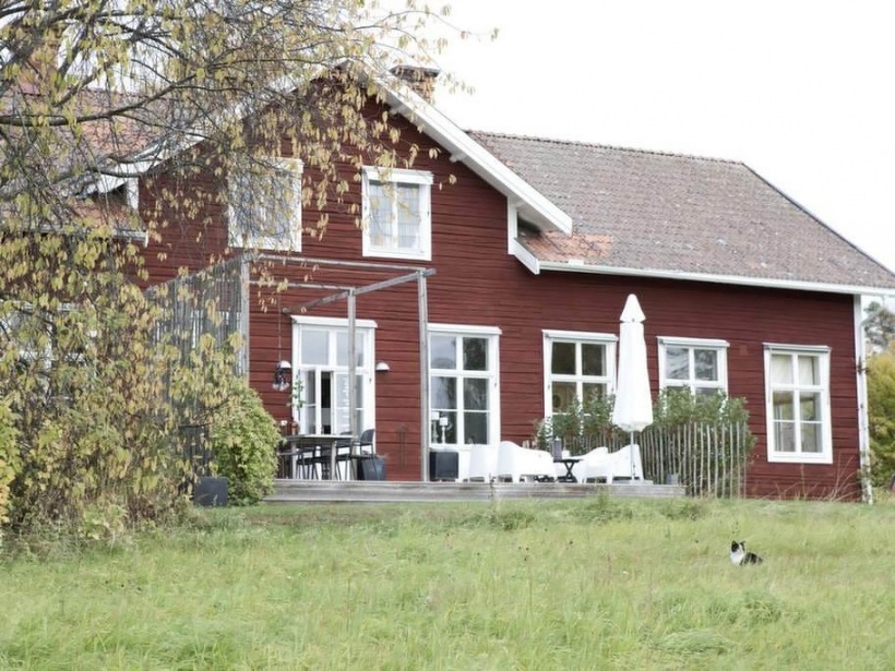 Brązowy dom  z bialymi oknami z tarasem z bialymi meblami