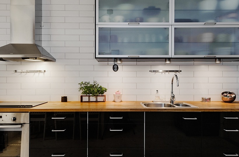 Nowoczesna czarno-biała kuchnia z przeszklonymi szafkami na ścianie
