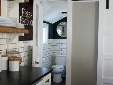 Do małej łazienki prowadzi wejście z kuchni. To wnętrze również ma bardzo oryginalną aranżację. Wystarczy spojrzeć na przesuwane drzwi po prawej stronie czy postarzaną...