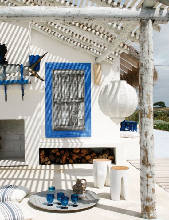 Biało-niebieski wakacyjny dom ze strzechą i bielonym drewnem