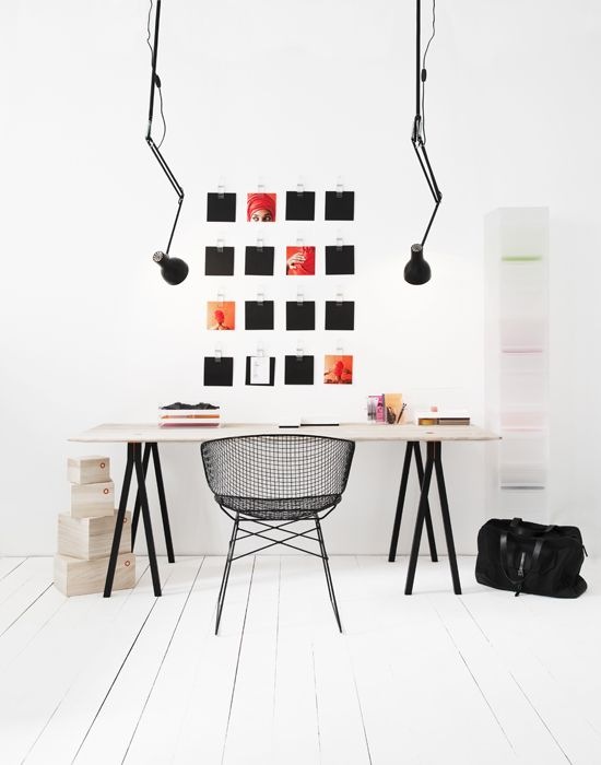 Biała podłoga,ażurowe czarne krzesło i skandynawskie biurko  z lampami na wysięgnikach