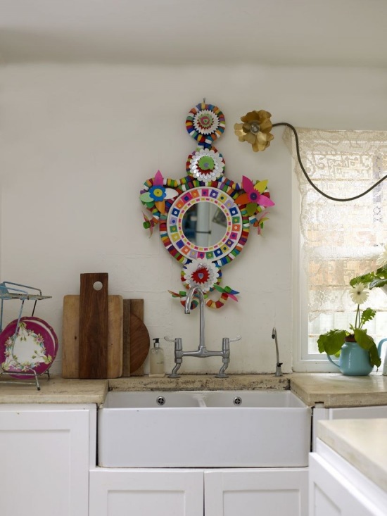 Kolorowe etniczne dekoracje na ścianie w białej kuchni