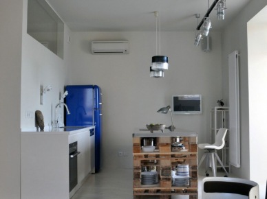 Niebieska lodówka, etniczny dywanik i wyspa kuchenna z drewnianych palet w białej kuchni (22129)