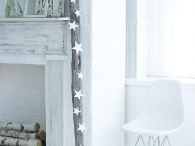Bielony portal kominkowy z drewnem w światecznej minimalistycznej dekoracji z białymi gwiazdkami (27427)