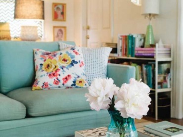 Przepiękny pokój dzienny z miętową kanapą i beżowymi detalami wprowadza cudowną atmosferę lekkości.  bezowy klosz, białe kwiaty, miętowa sofa i wzorzysta poduszka, wszystko to tworzy bardzo fajny...