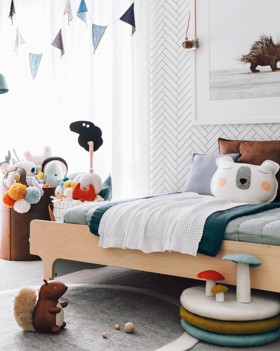 Drewniane łóżko i wzorzysta tapeta w pokoju dziecięcym