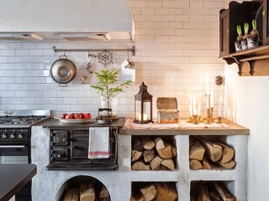 Biała glazurowana cegiełka na ścianie w wiejskiej skandynawskiej kuchni na opałowe drewno, schowki z drewnem pod blatem kuchennym (27456)