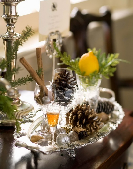Srebrne świeczniki i tace ze stylowym grawerem,szyszki naturalne i białe szkło na świątecznym stole