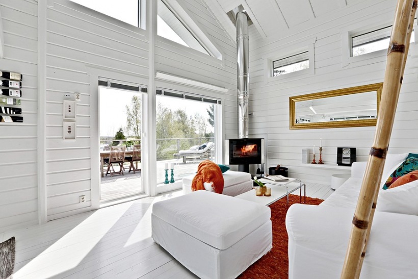 Złote lustro i rudy dywan w białym salonie w stylu skandynawskim