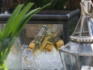 W letniej aranżacji tarasu zadbano o każdy szczegół. Na stoliku kawowym znalazły się nie tylko tworzące nastrój dekoracje, ale także praktyczny szklany pojemnik wypełniany lodem, który nadaje się do przechowywania schłodzonych...