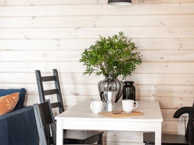 Oświetlenie nad stołem w jadalni ma typowo skandynawską formę. Dwie wiszące lampy w czarnym macie doskonale komponują się z krzesłami. Bielone deski na ścianie wprowadzają...
