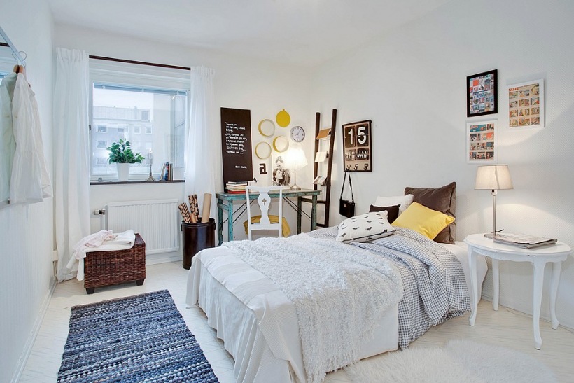 Skandynawska sypialnia z biurkiem, drabiną,wiklinową pufą i tkanym niebieskim dywanikiem