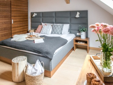 Łóżko, które ma pikowane wezgłowie, wygląda bardzo stylowo. Tworzy idealne połączenie z drewnem, bo sypialnia jest przytulna, ale też...