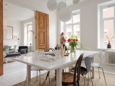 Postarzane dzrwi z białą patyną,biały stół prostokatny,różne krzesła w jadalni w stylu skandynawskim (25878)