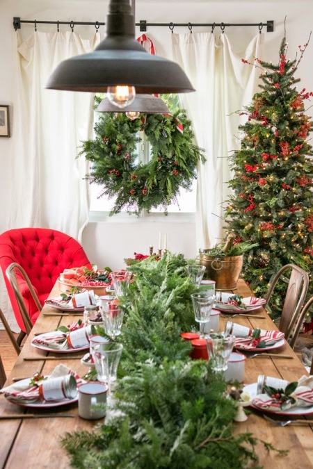Tradycyjne dekoracje świąteczne stołu z zielonym wiankiem i choinką z czerwonymi dekoracjami i krzesłami tolix