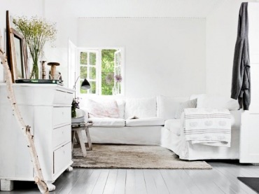 Biala komoda z szufladami,biały narożnik i drewniane dekoracje  w salonie (25555)