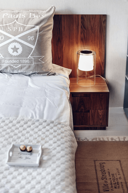 Nowoczesne drewniane brązowe łóżko w skandynawskiej sypialni
