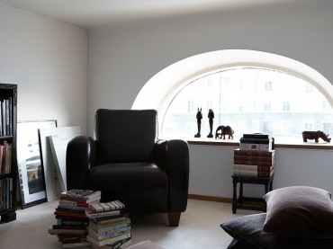 Pokój wypoczynkowy ze skórzanym fotelem na antresoli  w wysokim mieszkaniu (21239)