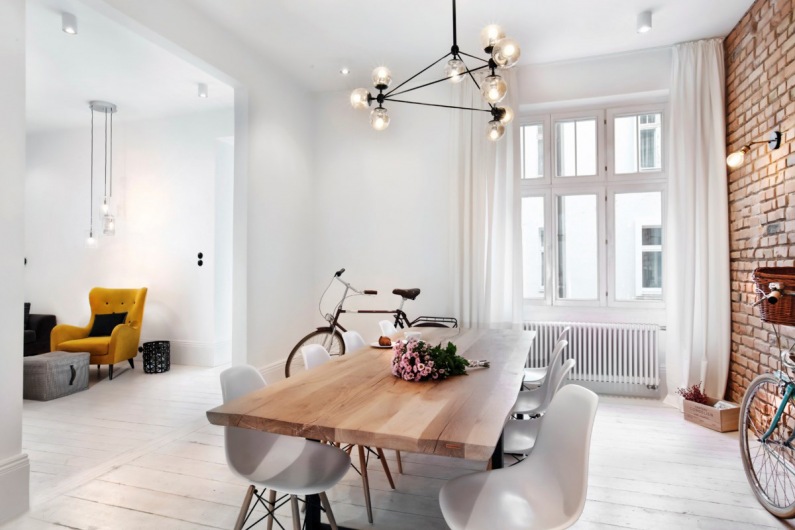 Drewniany stół i białe krzesła dobrze oddają klimat jadalni w stylu skandynawskim. Jasne tło, od podłogi, przez ściany,...